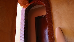 A staircase with a brick archway leading to a wooden door. - Auberge Benija (Anougal)