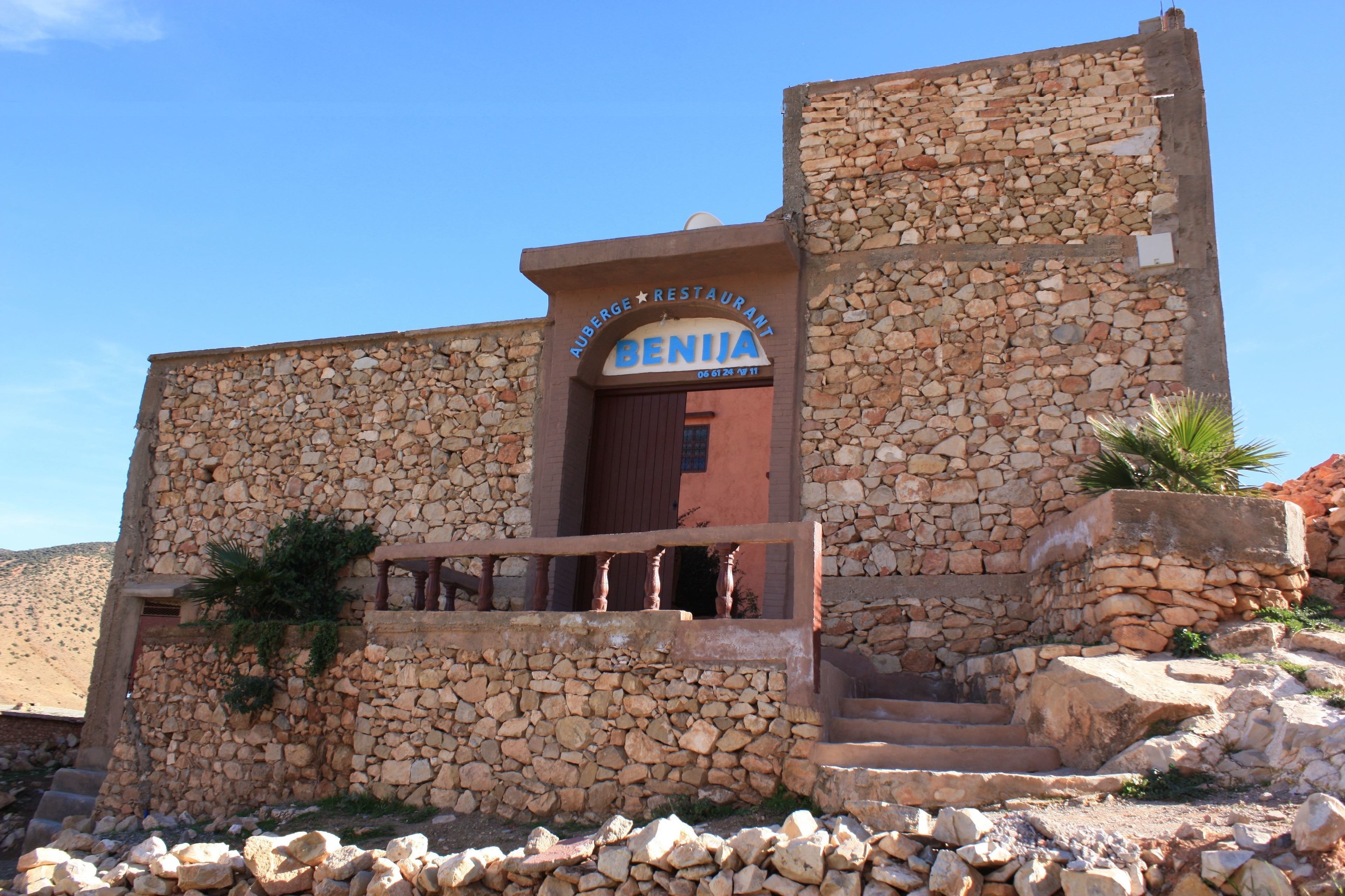 A stone building with a sign reading "Auberge Restaurant Benji."