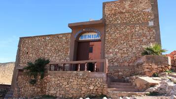 A stone building with a sign reading "Auberge Restaurant Benji."