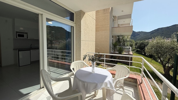 A balcony with a table and chairs, a small kitchen area, and a view of the surrounding landscape. - Agi Rescator 220 Apartamento for rent in Roses Girona. (Rosas / Roses)