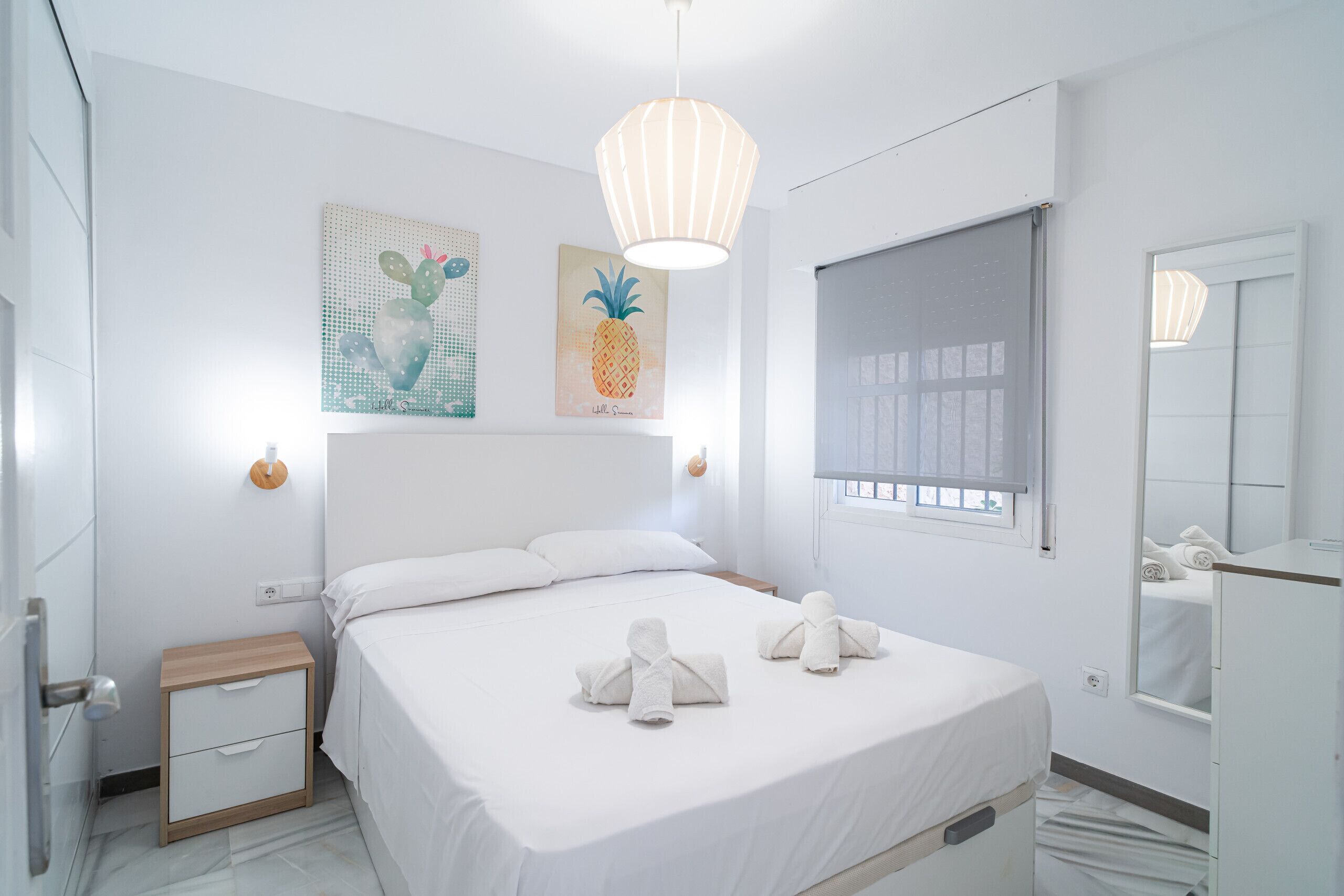 Une chambre d’hôtel moderne dotée d’un grand lit, d’une table de chevet, d’une commode, d’une fenêtre avec stores et d’œuvres d’art murales.