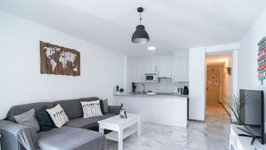 A modern living room with a grey sofa, white coffee table, and a world map artwork.