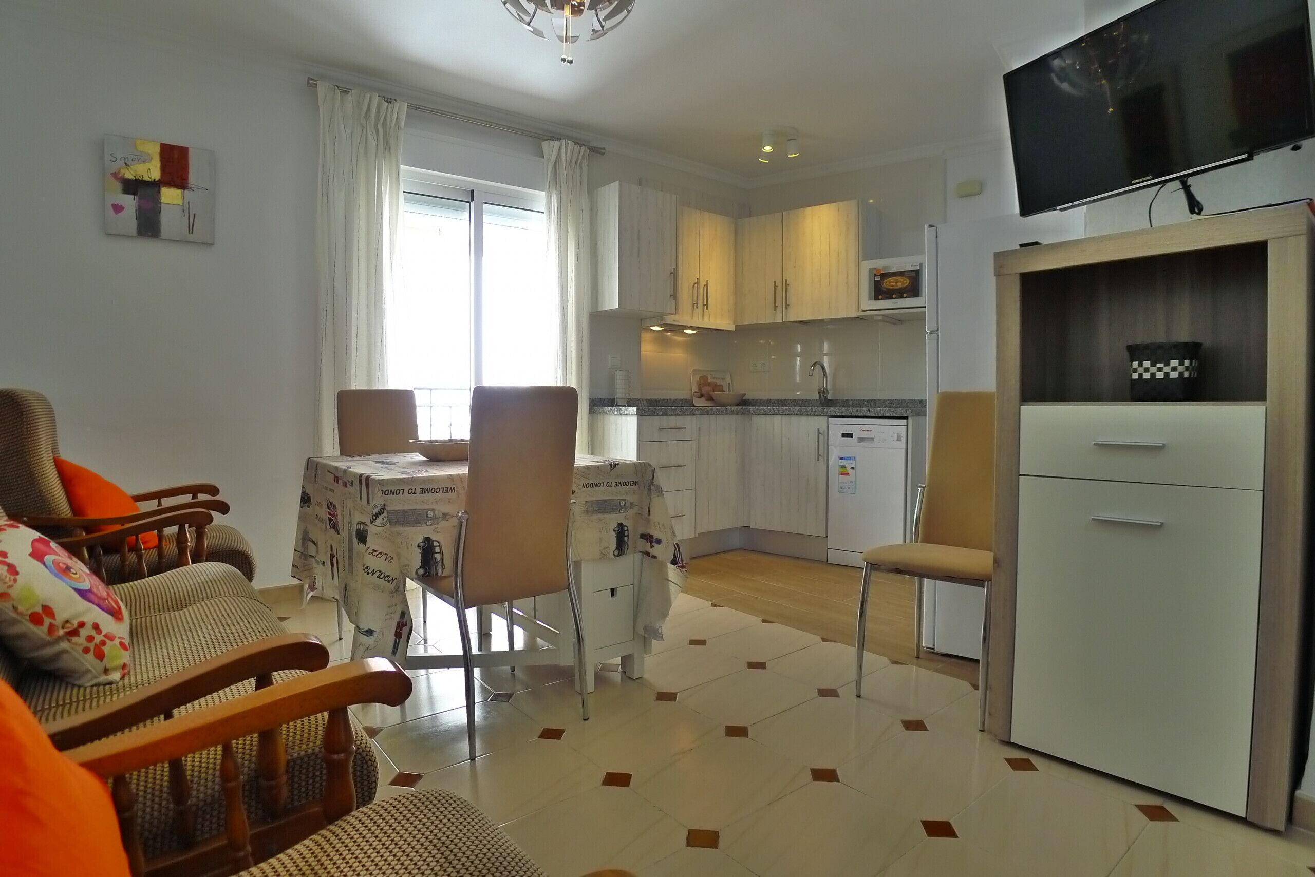Un espacio habitable compacto con comedor, cocina y zona de estar.