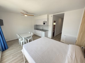 A compact hotel room with a bed, a kitchenette, a dining area, and a bathroom. - Agi Rescator 215 Apartamento for rent in Roses Girona. (Rosas / Roses)