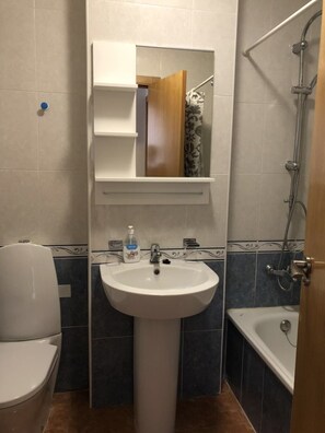 Ein Badezimmer mit Waschbecken, Toilette, Badewanne und Dusche.