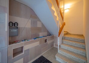 A modern staircase with a wooden handrail and a check-out machine on the wall.