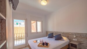 Un dormitorio con cama, mesita de noche y una bandeja con artículos de aseo.