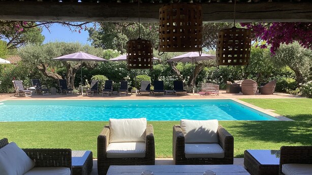 A poolside area with wicker furniture, a white table, and hanging wicker lanterns. - Modern Provencal Villa -  (Ramatuelle)