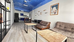 Een moderne woonkamer met een blauw plafond, een bank, een salontafel en een boekenkast.