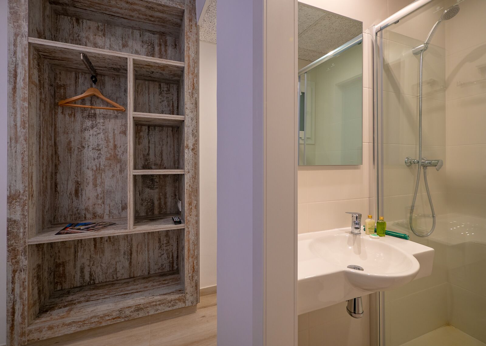 Un baño con un estante de madera, un lavabo y una ducha.