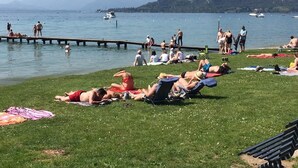 A sunny day at a lakeside with people sunbathing and relaxing on the grass. - DREAM HOLIDAY ON LAKE GARDA (Lazise)