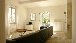 A room with a sofa, a small table, a radiator, and a lamp.