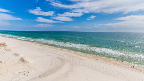 Une plage avec un ciel dégagé et une mer calme.
