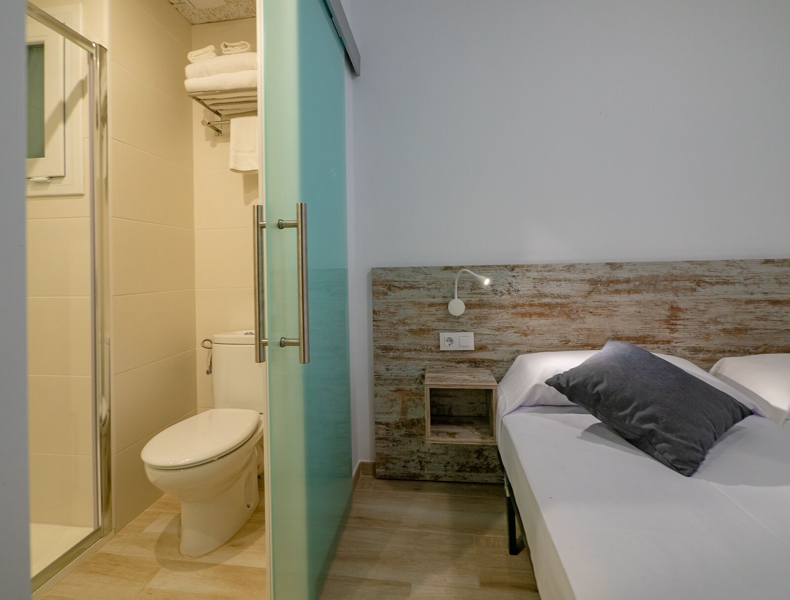 Une salle de bain moderne avec des toilettes, une douche et une porte en verre.