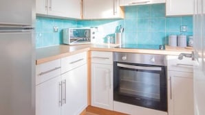 A modern kitchen with white cabinets, a built-in oven, and a microwave. - The Cluthar: Ground Floor West End /City Centre / Rockvilla Flat & Parking (Glasgow)