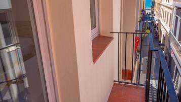 A narrow corridor with a small window and a metal railing.