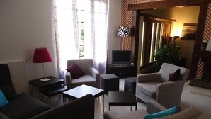 A living room with a sofa, armchairs, a coffee table, a TV, and a lamp. - Comfortable Solognote house for a pleasant family holiday (Dhuizon)