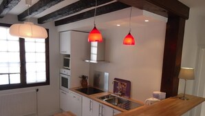A modern kitchen with white cabinets, a wooden countertop, and pendant lights. - Comfortable Solognote house for a pleasant family holiday (Dhuizon)