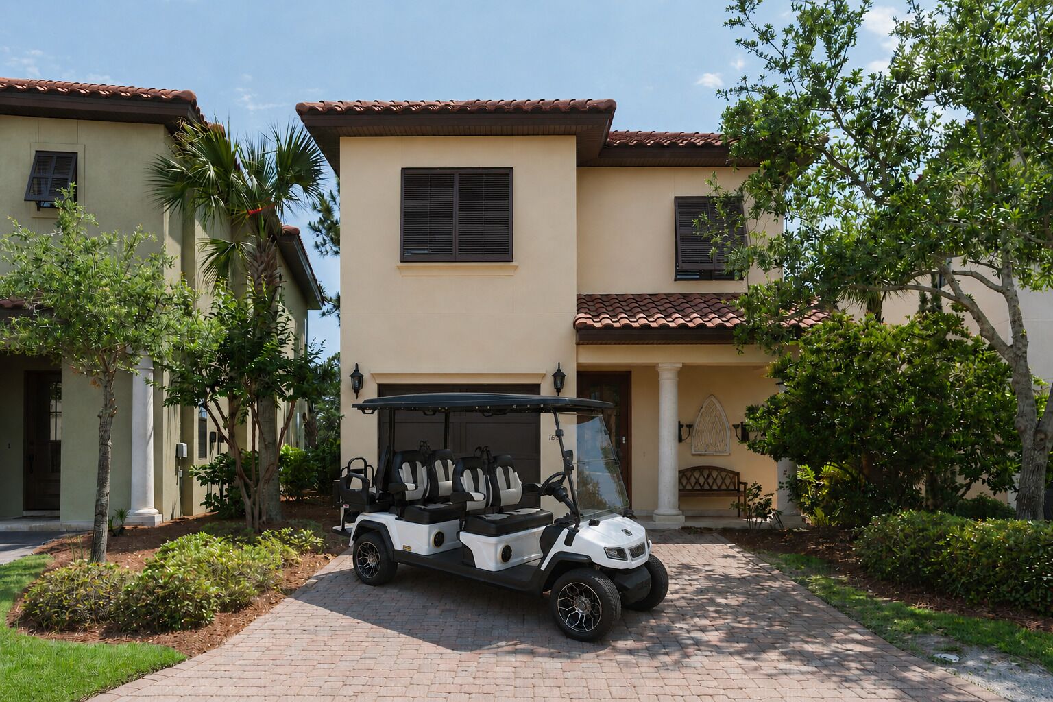 A golf cart parked in front of a building with a tiled roof and a garage door.
