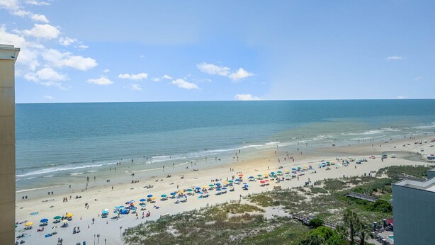 A beach with umbrellas and people. - Family Fun at this Beachside Resort in Myrtle Beach (Myrtle Beach)