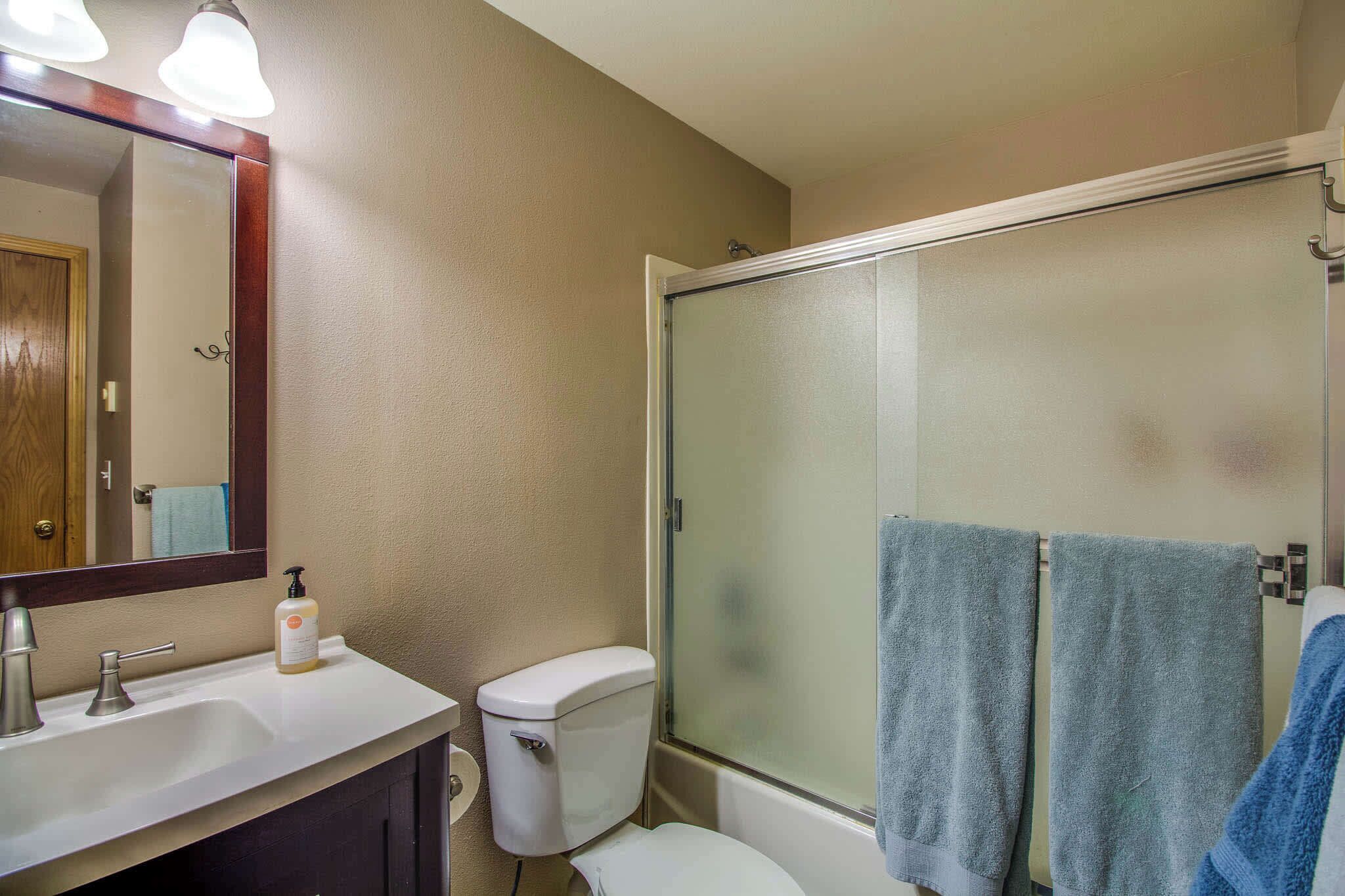 A bathroom with a sink, toilet, and glass-enclosed shower.