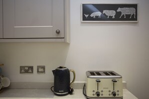 A kitchen with a Breville kettle, a toaster, and a wall-mounted power outlet. - Quiet, City Garden Apt. Pets Allowed (PL) (Bath)