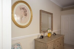 A room with a wooden dresser, a mirror, and a framed portrait on the wall. - Quiet, City Garden Apt. Pets Allowed (PL) (Bath)