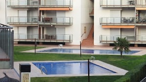 A residential building with multiple balconies, a swimming pool, and a small garden area. - Residencial complex les marines  (Roses)