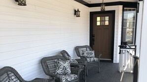 Een veranda met rieten meubels en een deur.