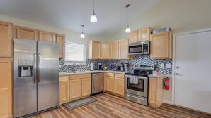 Una cocina moderna con armarios de madera, electrodomésticos de acero inoxidable y un salpicadero estampado.