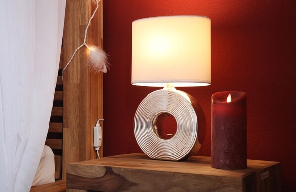 Una mesita de noche de madera con una lámpara y una vela.