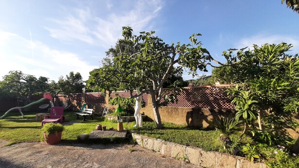 Un jardin avec un espace de jeux, une statue et un mur en briques.