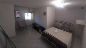 Une chambre à coucher avec un lit, un bureau, une chaise et une fenêtre.
