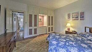 Ein Schlafzimmer mit Bett, Nachttisch, Lampe und Kleiderschrank.