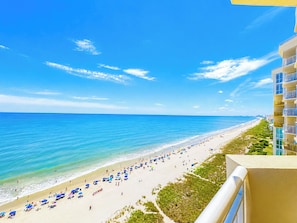 Vista de la playa con un edificio a la derecha.