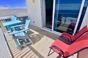 Enjoy ocean views from this balcony with a dining area and seating.