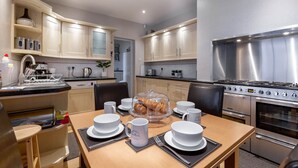 A modern kitchen with a dining area, stainless steel appliances, and a breakfast setup. - ❤️ Large Family Self Catering Holiday House-Filey (Filey)