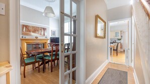 A dining area with a wooden table and chairs, a fireplace, and a large mirror on the wall. - ❤️ Large Family Self Catering Holiday House-Filey (Filey)
