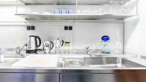 Una cocina moderna con electrodomésticos de acero inoxidable, un lavabo y un escurreplatos.