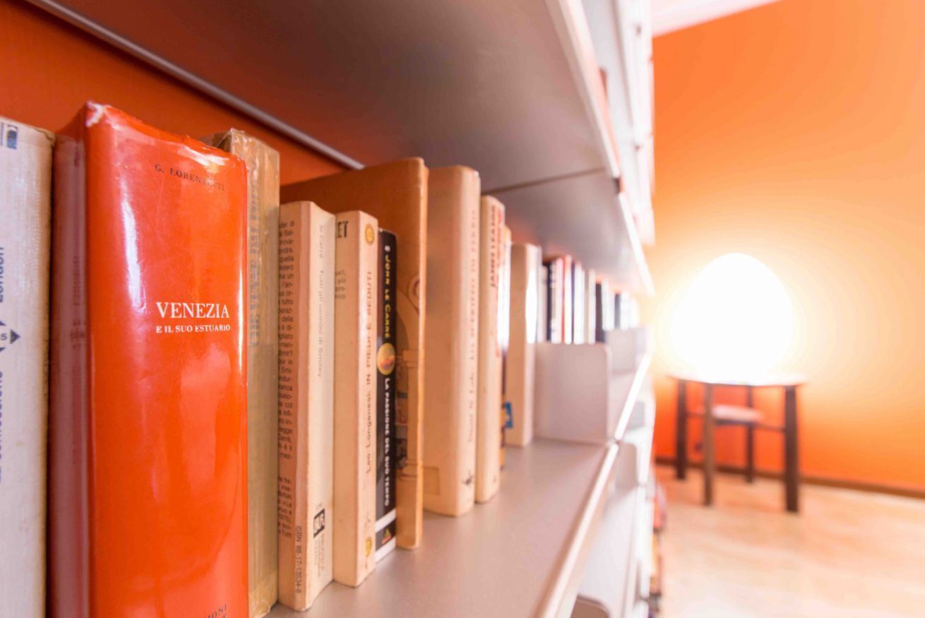 A bookshelf with books, including one titled "VENEZIA E IL SUO ESTUARIO".