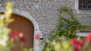 A stone building with a large arched doorway and a window. - Cottage 4 people for lovers of the countryside (Poiseul-la-Ville-et-Laperrière)