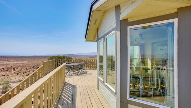 Eine Terrasse mit Tisch und Stühlen mit Blick auf eine Wüstenlandschaft.