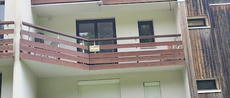 Un edificio de varios pisos con balcones, ventanas y fachada de madera.