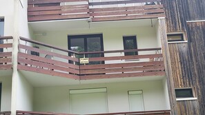 Un edificio de varios pisos con balcones, ventanas y fachada de madera.