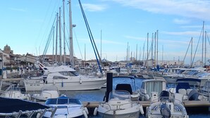 Ein Yachthafen mit verschiedenen Schiffen, darunter Segelboote und Motorboote.