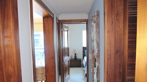 Un couloir avec des portes en bois et une vue sur une chambre à coucher.