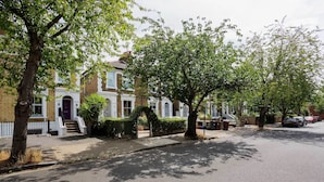 A residential street with houses, trees, and parked cars. - The Gallery of Colour, by Veeve (London)