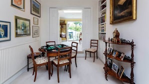 A dining area with a pool table, wooden chairs, and a bookshelf with framed pictures. - The Gallery of Colour, by Veeve (London)