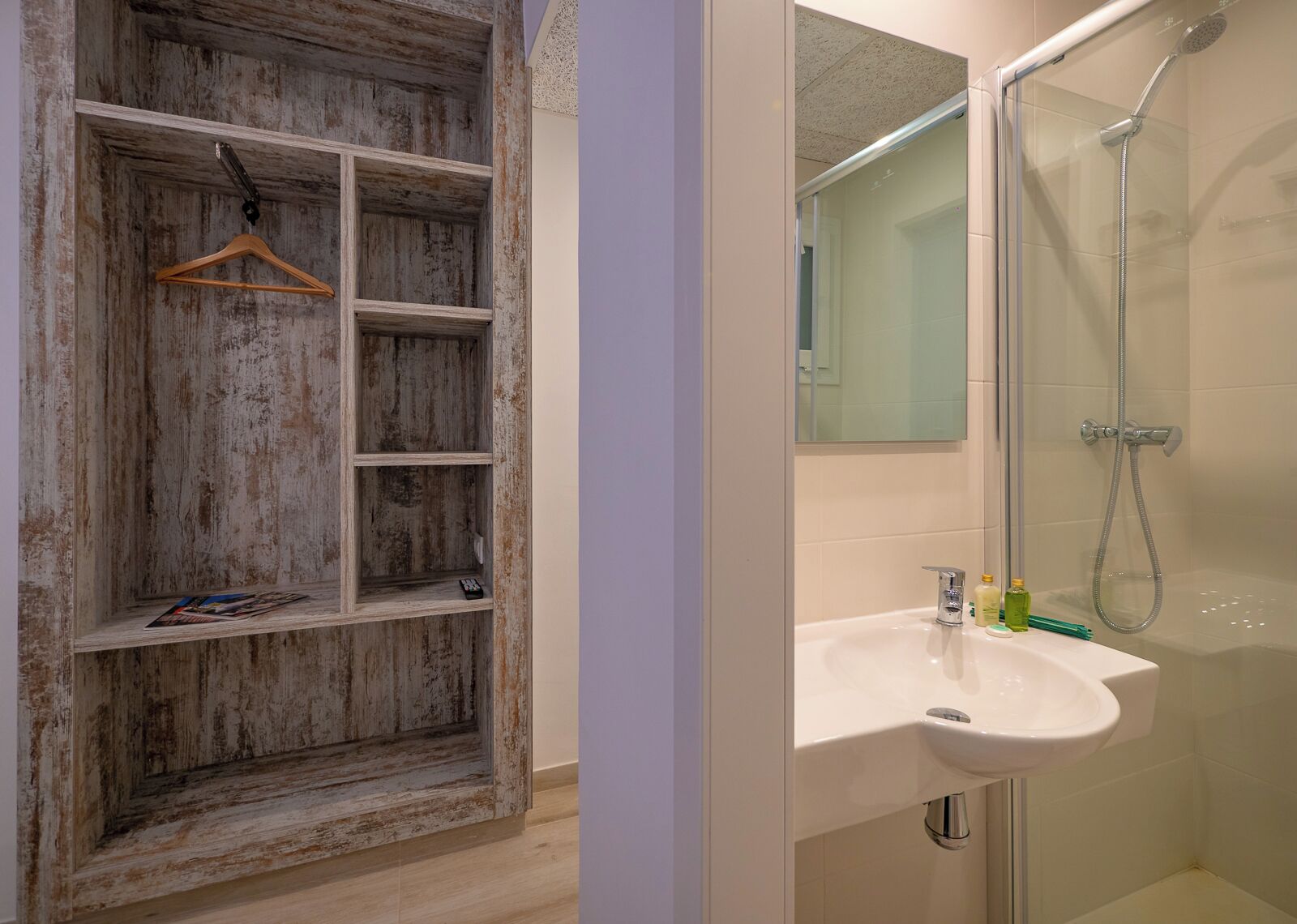 Une salle de bain avec une étagère en bois, un lavabo et une douche.