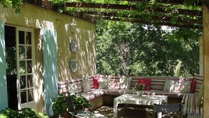 A covered patio with a seating area, a table, and chairs. - Idyllic St Tropez location with pool. Tranquil setting close to all the action. (Ramatuelle)